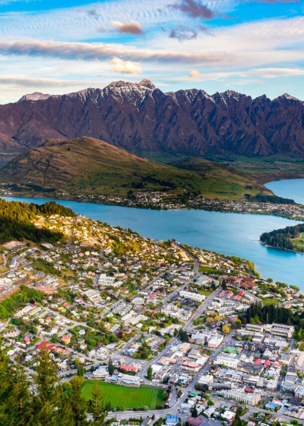 Blick über eine Küstenstadt, die von einer Bergkette gesäumt wird