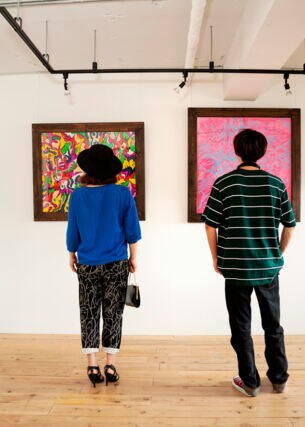 Ein Mann und eine Frau stehen in einer Kunstgalerie und betrachten Gemälde