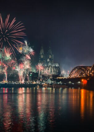 Feuerwerk an Silvester in Köln, Blick auf den Rhein, im HIntergrund der Kölner Dom.