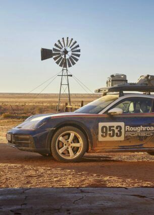Porsche 911 Dakar im Rallye-Design in der Seitenansicht vor einer Wüstenlandschaft