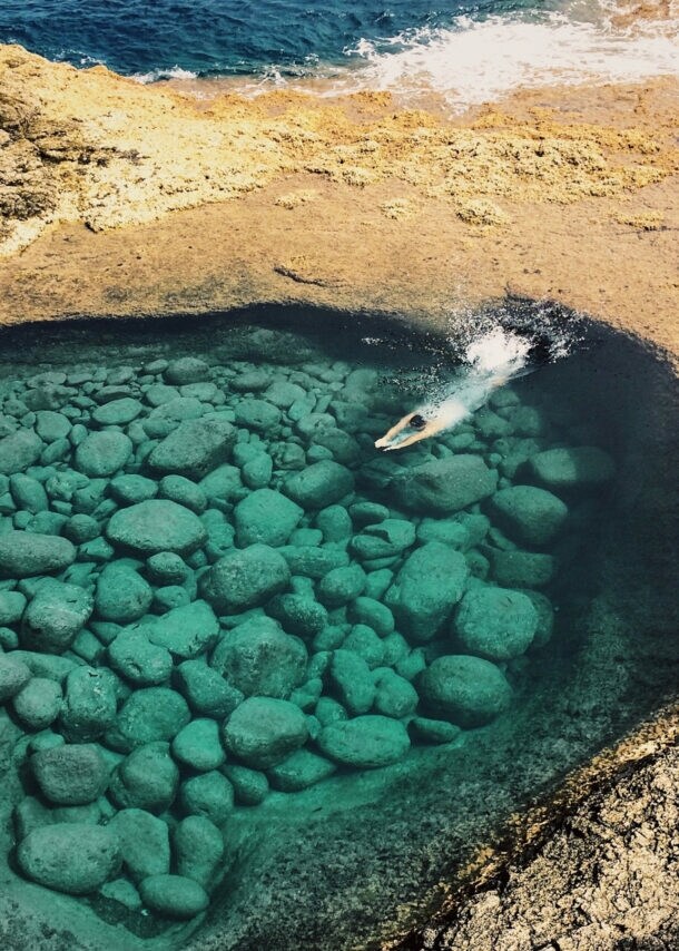 Luftaufnahme einer Person, die in eine Bucht eintaucht