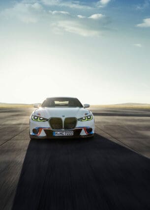 Weißes, sportliches BMW-Auto von vorne auf einer leeren Straße