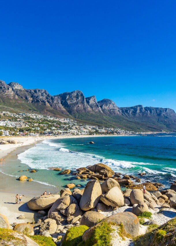 Felsige Strandbucht bei Kapstadt mit Gebirgskette im Hintergrund