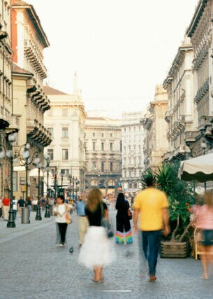 Menschen auf einer belebten Straße mit Bars und Restaurants in Mailand