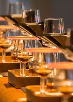 Mit Hennessy gefüllte Cognac-Gläser auf einem abgerundeten Holztresen