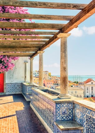 Terrasse mit portugiesischen Kacheln und Bougainvillea mit Blick auf Lissabon am Meer