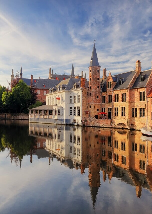 Historisches Zentrum von Brügge mit mittelalterlichen Gebäuden, die sich im Wasser spiegeln.