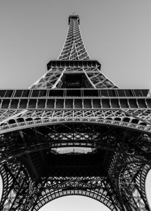 Schwarzweißaufnahme des Eiffelturms aus der Froschperspektive