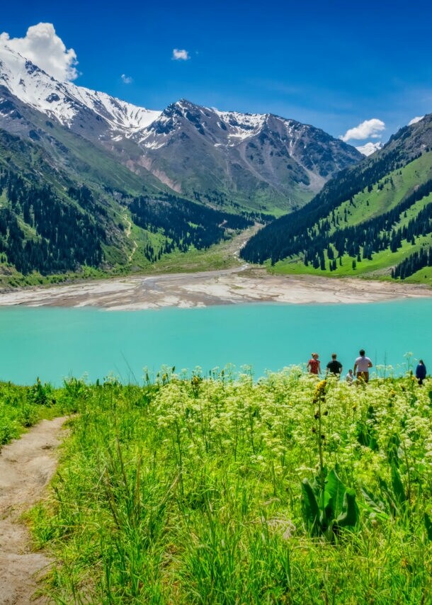 Blick auf den Almaty See in Kasachstan, der in ein Gebirge gebettet ist.