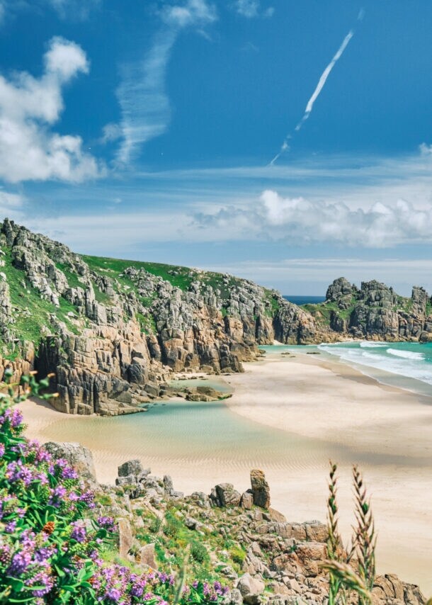 Blick auf die Küste von Cornwall mit Sandstrand, kristallblauem Wasser und Felsvorsprüngen