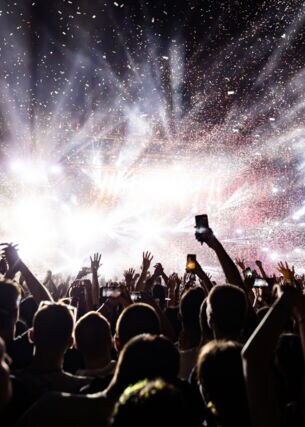 Jubelnde Zuschauermenge mit Blick auf die Bühne auf einem Musikfestival bei Nacht