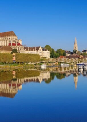Stadtpanorma von Auxerre mit Kathedrale und Abtei, davor Boote auf einem Fluss