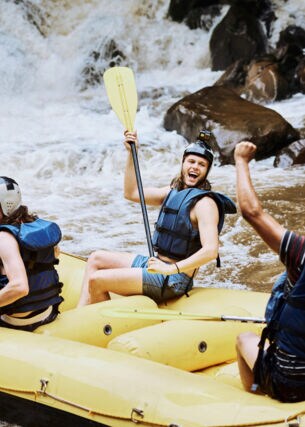 Aufnahme einer Gruppe fröhlicher Personen in einem Schlauchboot, die einen wilden Fluss hinabfahren