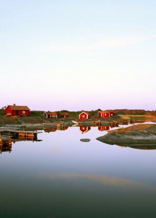Blick auf rote Holzhäuser auf einer Insel in Schweden