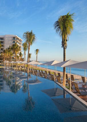 Eine Hilton Hotelanlage mit Pool an einem Sandstrand