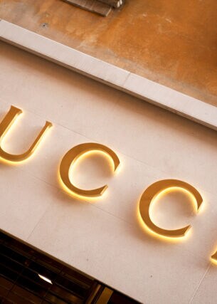 Das Logo von Gucci in Goldlettern an einer mediterranen Hausfassade