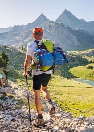 Rückansicht von zwei Wandernden mit Rucksäcken vor Bergpanorama in den Pyrenäen