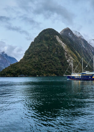 Ein Schiff vor einem Bergmassiv in Neuseeland