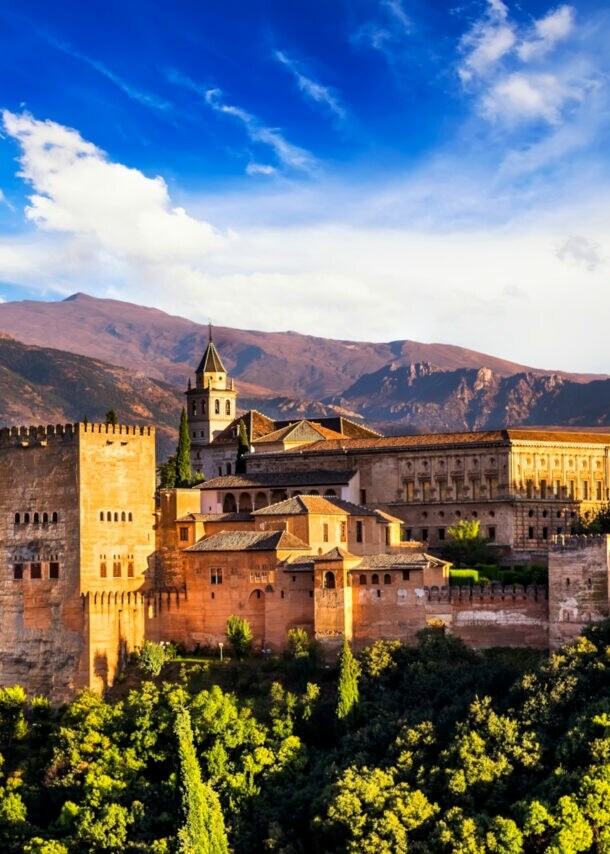 Eine Burgfestung in bergiger und mit Bäumen bewachsener Umgebung
