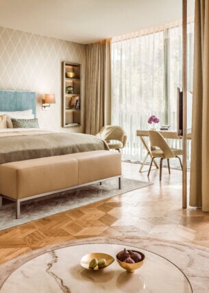 Moderne, helle Hotelsuite mit Parkettboden und bodentiefen Fenstern.