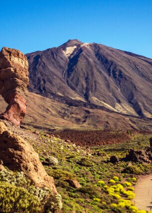 Eine Vulkanlandschaft mit Felsen und einem großen Berg im Hintergrund.