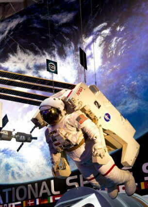 Die International Space Station und ein Astronaut als hängende Modelle in einem Museum.