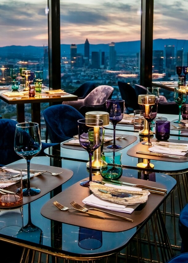 Räumlichkeiten des Restaurant Franziska mit der Skyline Frankfurts im Hintergrund.