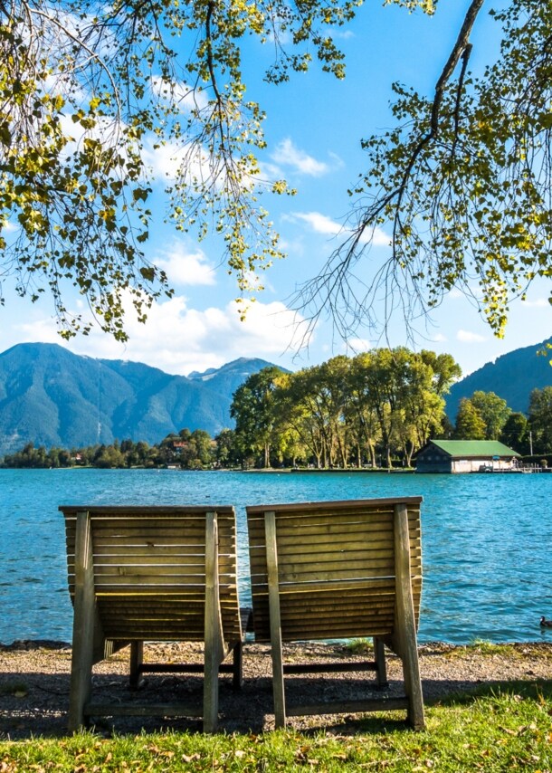 Zwei Holzliegen am Ufer des Tegernsees.