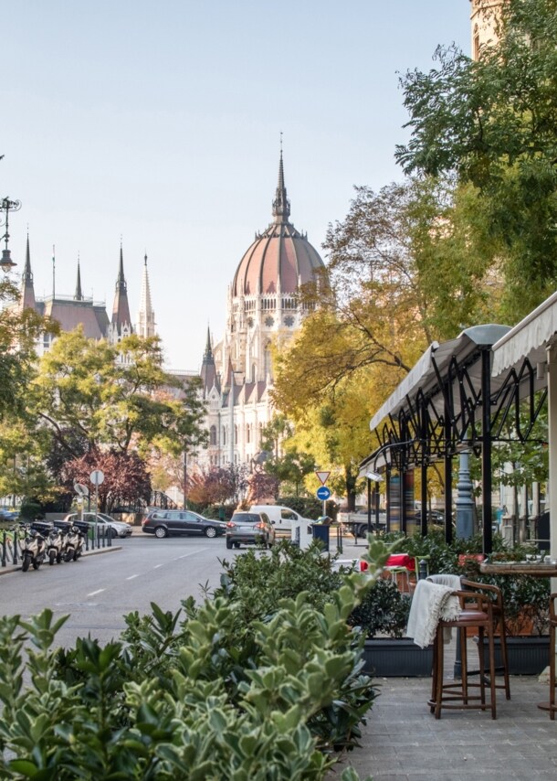 Straßenaufnahme in Budapest mit der Kuppel des Parlamentsgebäudes im Hintergrund. 