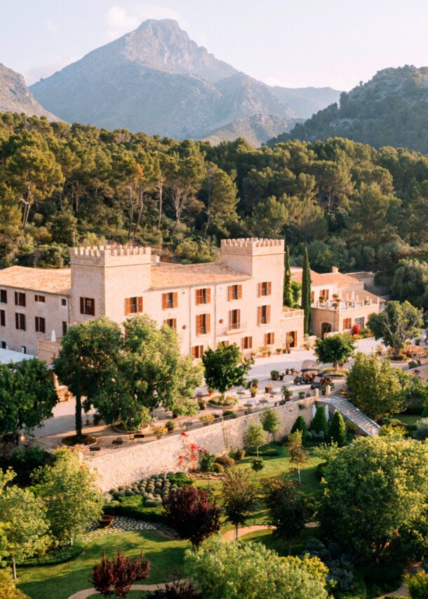 Das historische Hotel Castell Son Claret mit seiner grünen Parkanlage vor der Kulisse des Tramuntana-Gebirges.