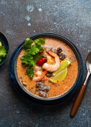 Thai-Suppe Tom Yum mit Meeresfrüchten in einer Keramikschüssel von oben