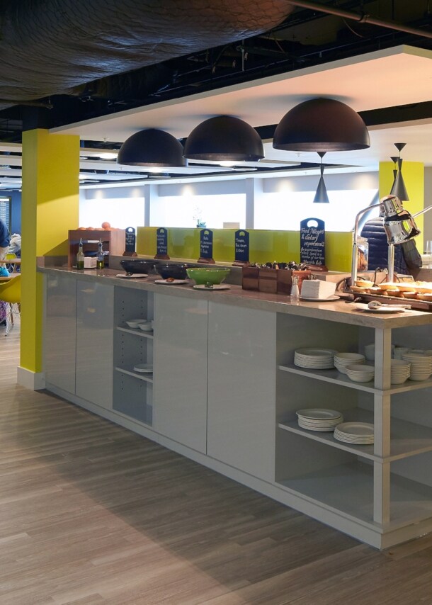 Personen in einer Flughafenlounge mit Buffet.