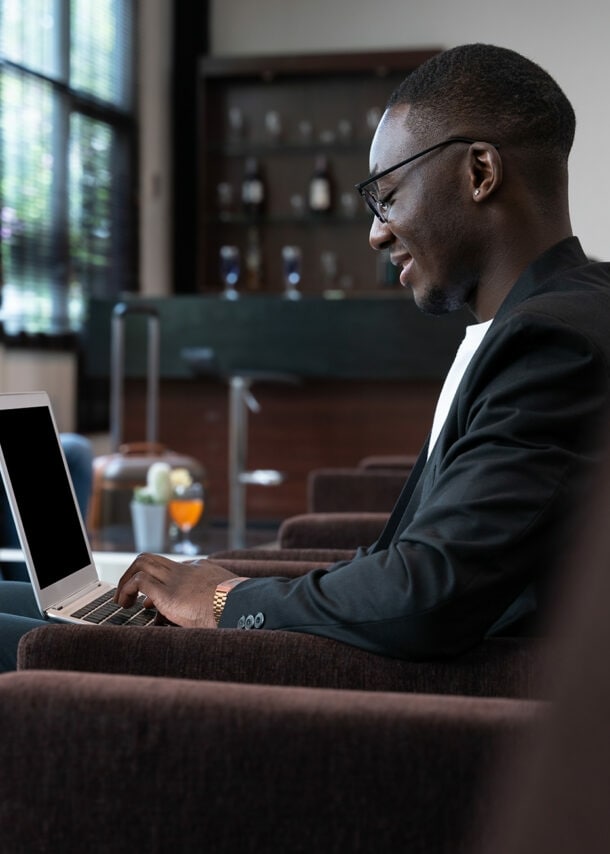 Ein Geschäftsmann arbeitet in Hotellobby am Laptop.