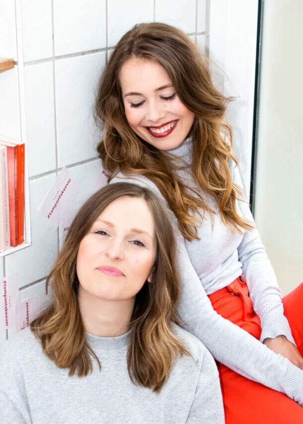 Die Gründerinnen von The Female Company sitzen entspannt am Fenster.