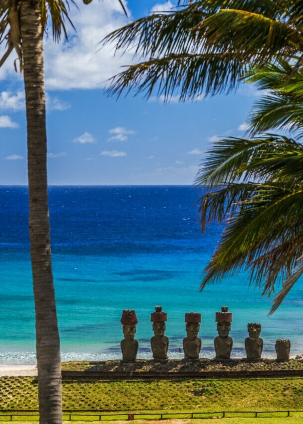 Strand auf der Osterinsel, an dem eine Reihe von Steinfiguren stehen, mit Blick auf den Pazifik.
