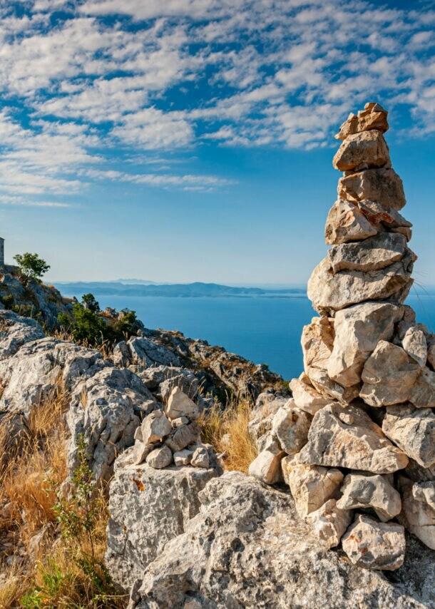 Blick von einem felsigen Berg aufs blaue Meer. 