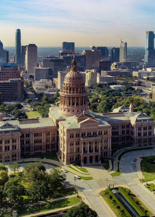 Texas State Kapitolgeböude vor der Skyline von Austin aus der Luftperspektive.