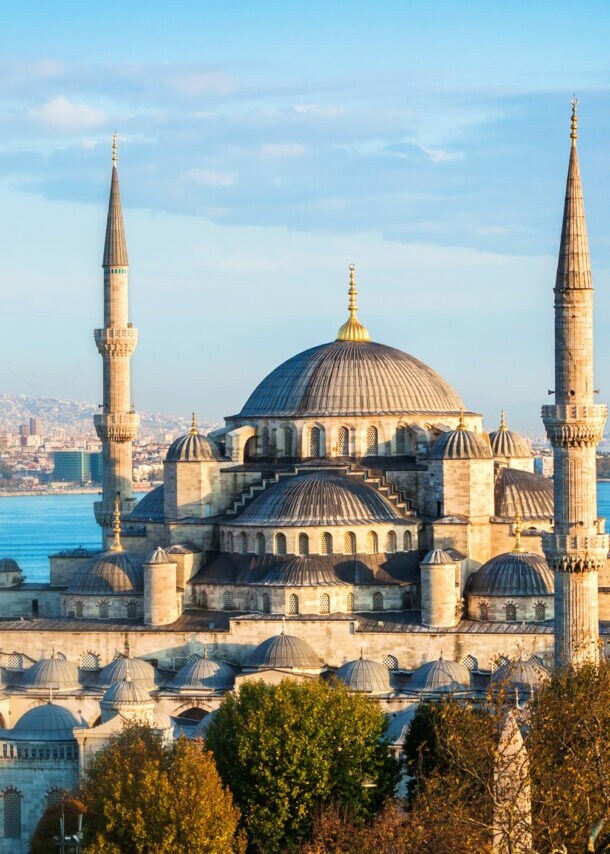 Große Moschee am Wasser vor dem Stadtpanorama von Istanbul unter blauem Himmel.