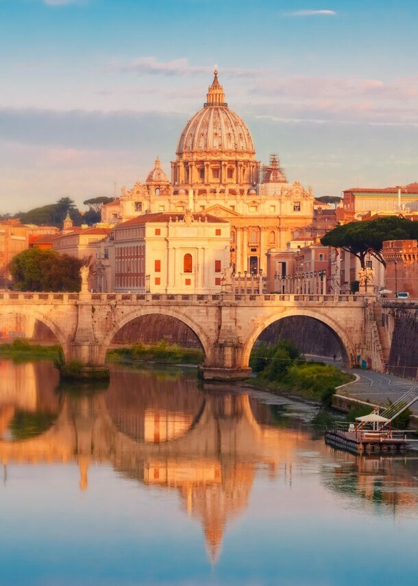 Stadtpanorama von Rom mit Petersdom am Fluss im warmen Sonnenlicht.