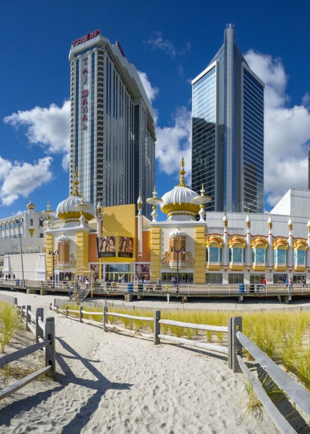 Strandpromenade mit Gebäude im orientalischen Stil vor Hochhäusern unter blauem Himmel.
