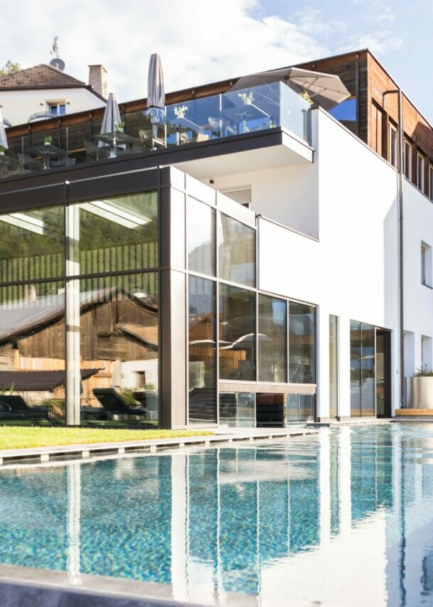 Blick auf das Hotel Weisses Kreuz mit Außenpool im Vordergrund.