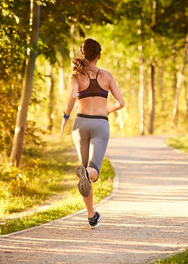 Eine Frau joggt am frühen Morgen im Park.
