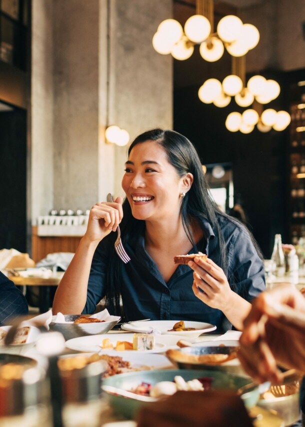 Vier fröhliche Menschen an einem Tisch im Restaurant.