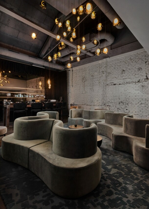 Gastraum in edlem Design, mit geschwungenen Polstermöbeln und einem Ambiente in Industriestil.
