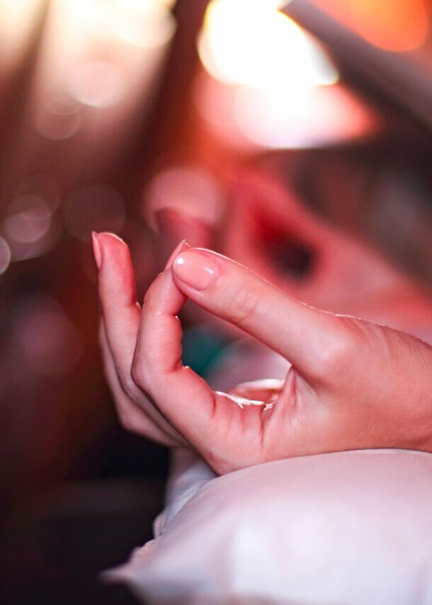 Hand in Meditationshaltung auf einem Kissen in einem Flugzeugsitz