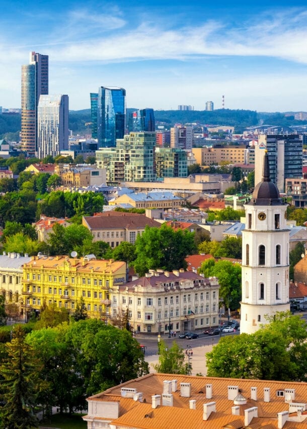 Stadtpanorama von Vilnius mit Kirchturm in Altstadt vor modernen Hochhäusern im Hintergrund.