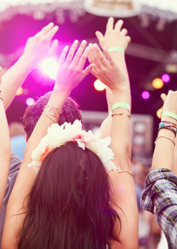 Jubelnde Personen von hinten vor eine Bühne.