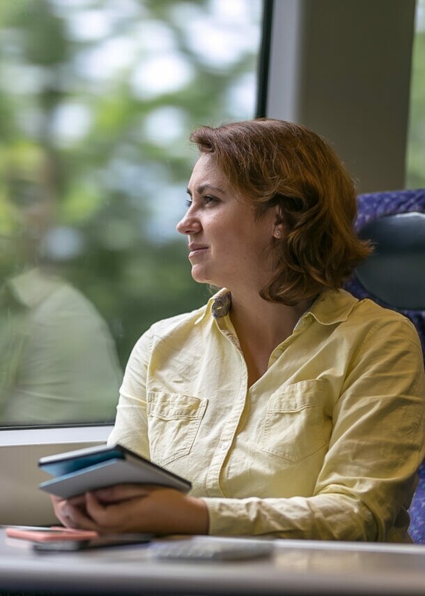 Eine Geschäftsfrau reist klimafreundlich im modernen Zug.