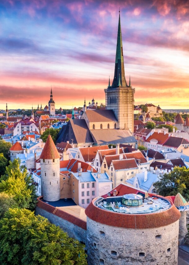 Luftaufnahme der Tallinner Altstadt bei Sonnenuntergang im Sommer, mit dem Turm der „Dicken Margarete“ im Vordergrund.