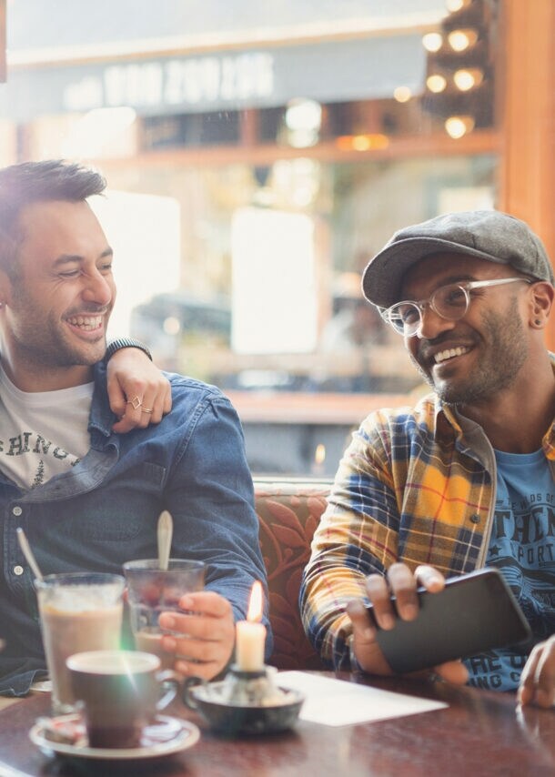 Gäste im Restaurant nutzen eine Buchhaltungsapp auf dem Smartphone.